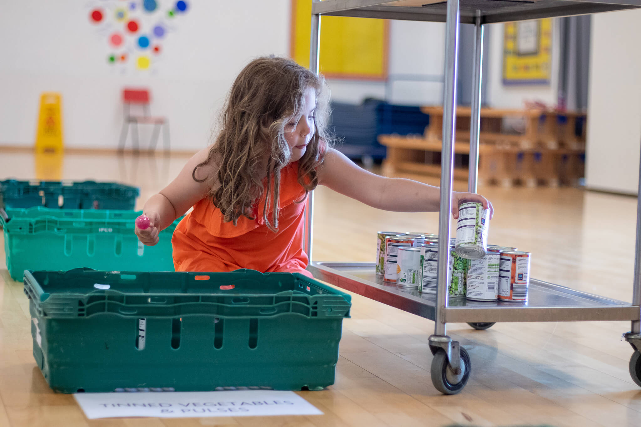 girls puts tins on trolley