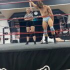 a wresting referee raises the winner's hand