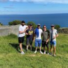 Five men in a field by the sea