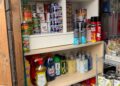 A shelf unit packed with tins and bottls