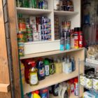 A shelf unit packed with tins and bottls