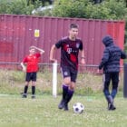 a teenage boy kicking a football