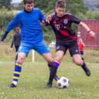 two teenagers compete for a football