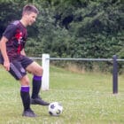 a teenage boy kicking a football