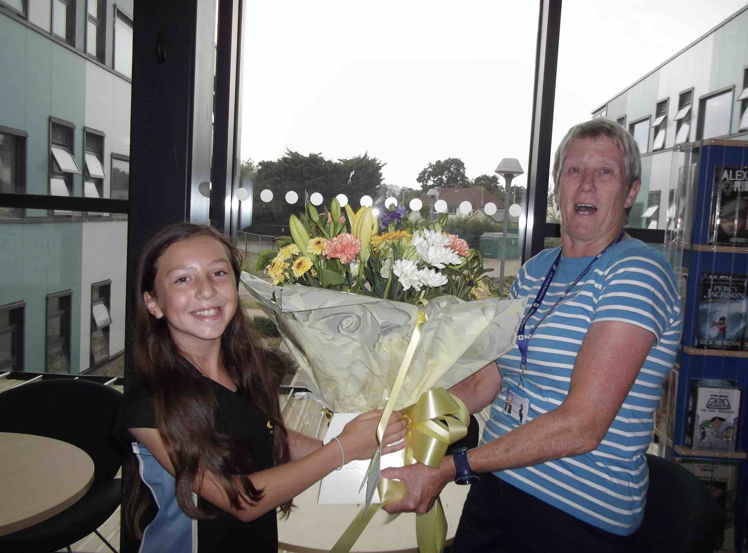 a girl gives flowers to a woman