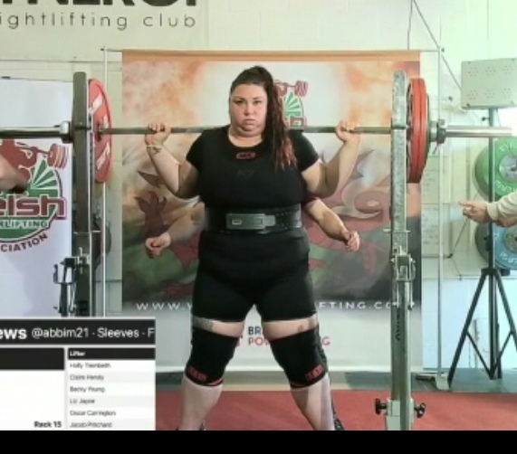 a woman with barbell on shoulders