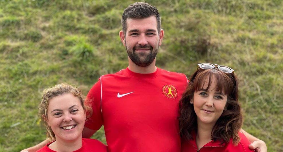 Two women and a man in red t-shirts