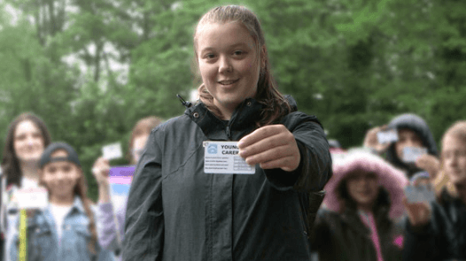 a girl holds an ID card up