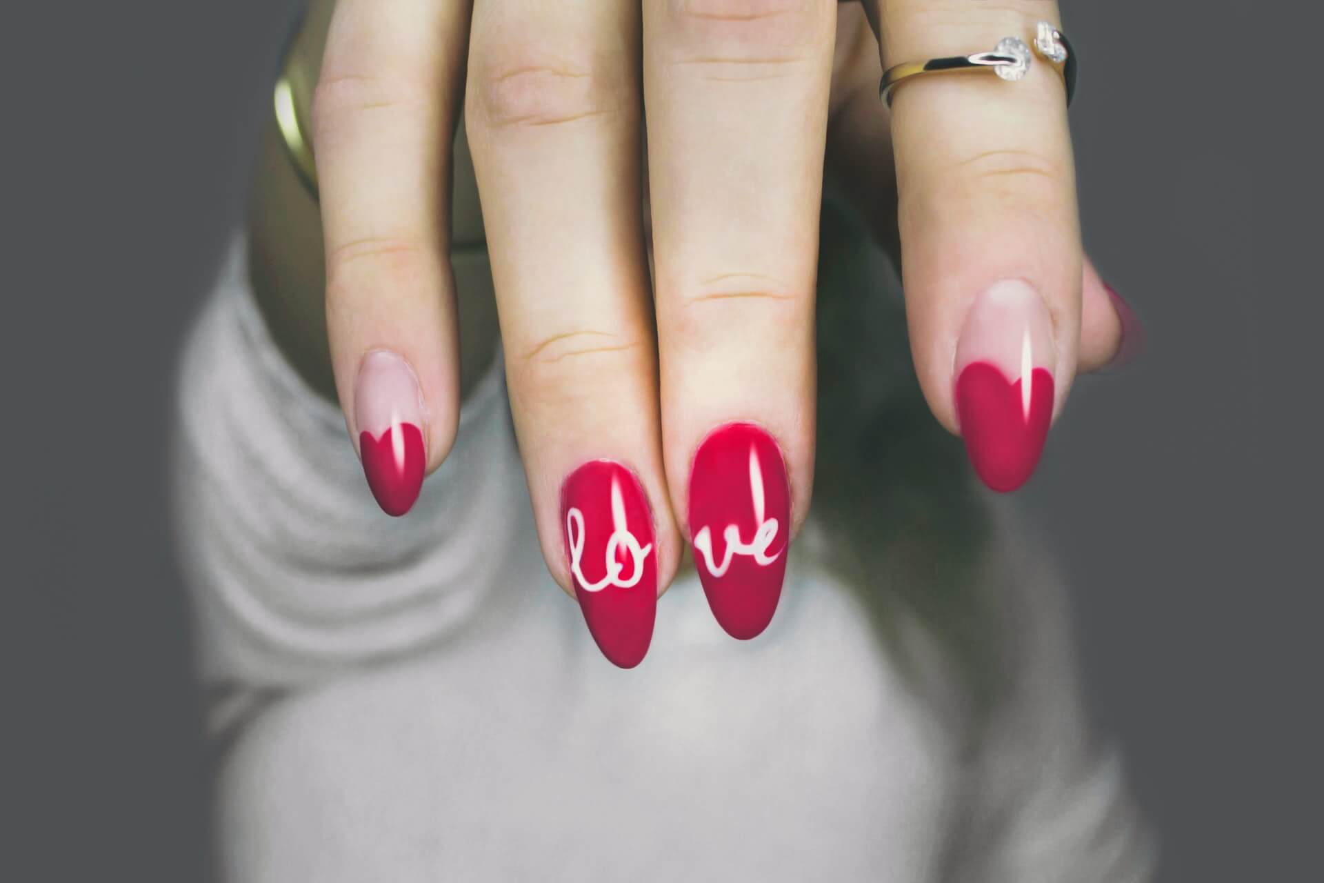 a hand with red painted nails and word love