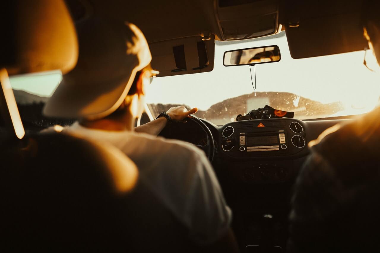 man driving car on sunny day