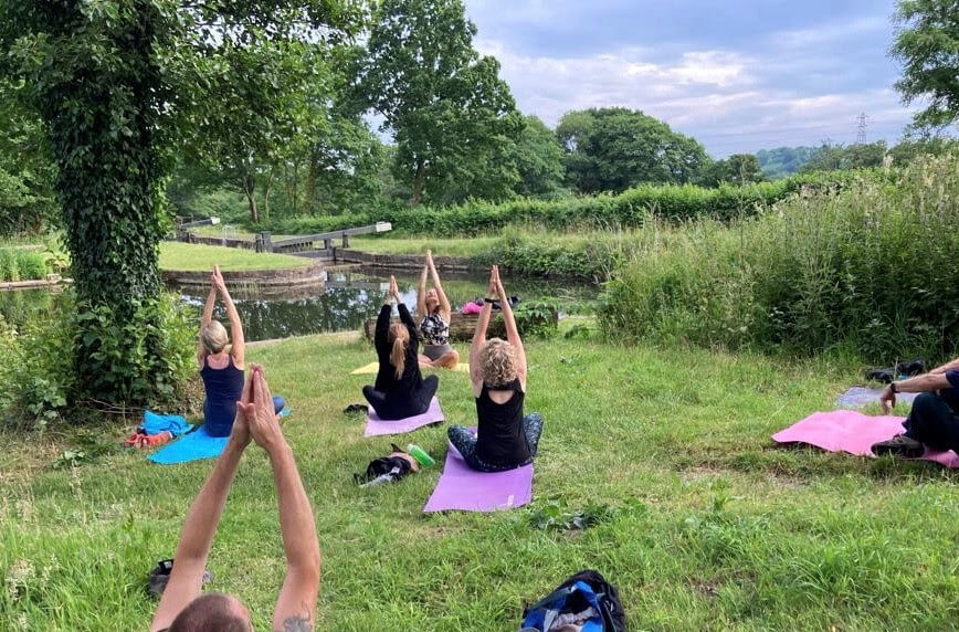 people doing yoga by a canal