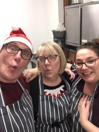 a man and two women in a kitchen