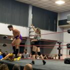 a wrestler climbs the ropes