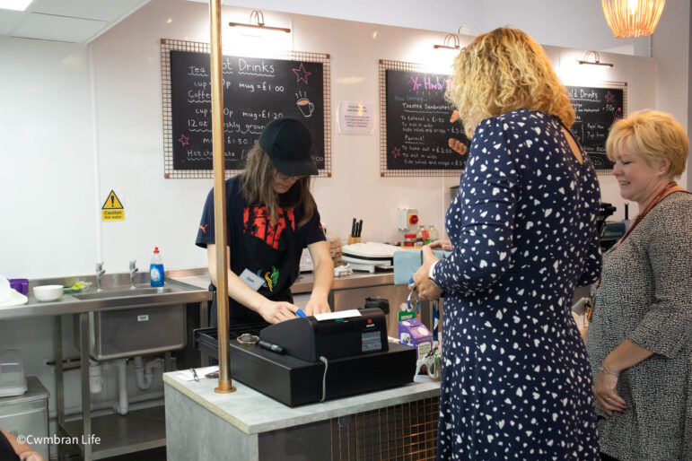 man getting change for customer in a cafe