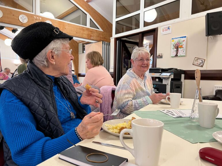 Two women eat lunch at a table