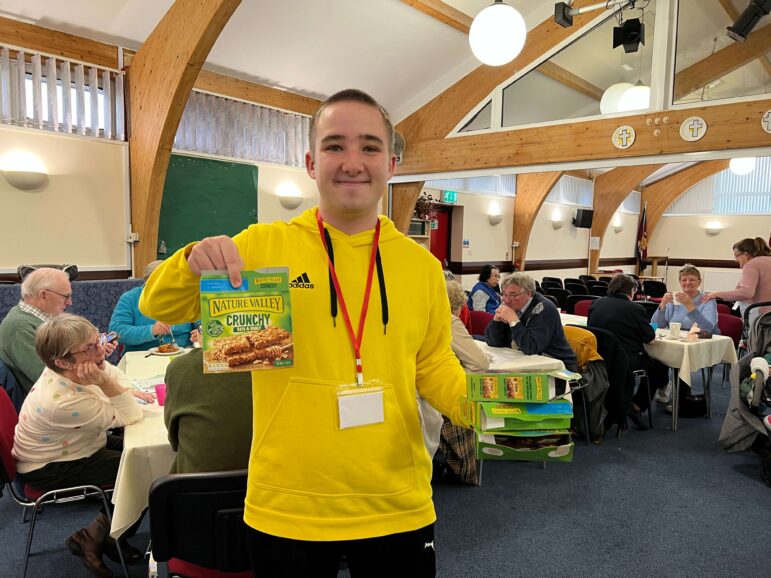 a teenage boy volunteers at a lunch club