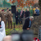 man laying wreaths bows his head