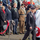 man carries a poppy wreath