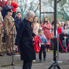 woman lays a poppy wreath