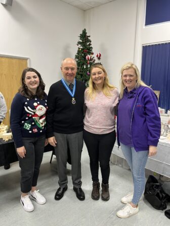 four people stood by christmas treet