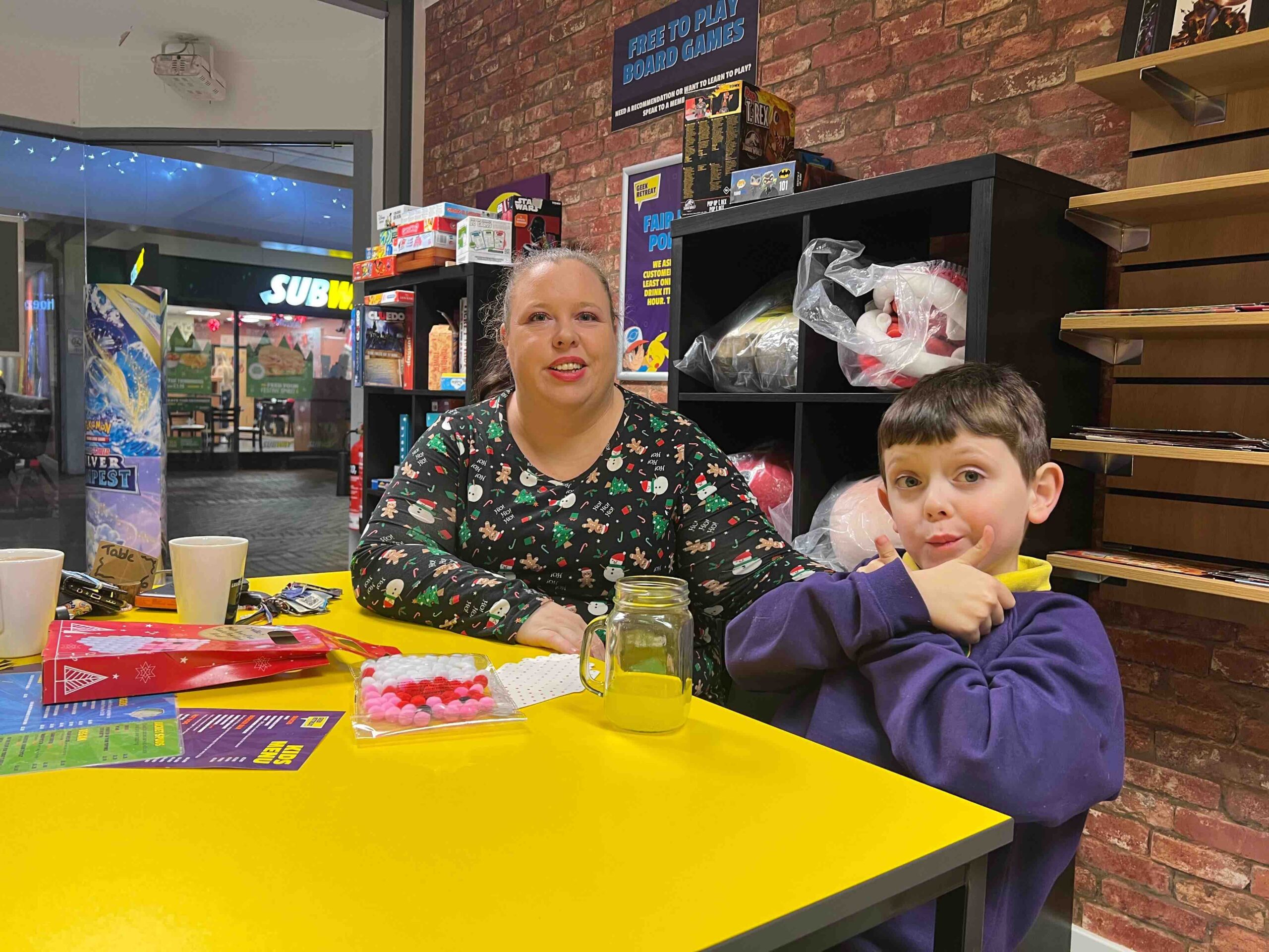 mum and son at table in board game shop