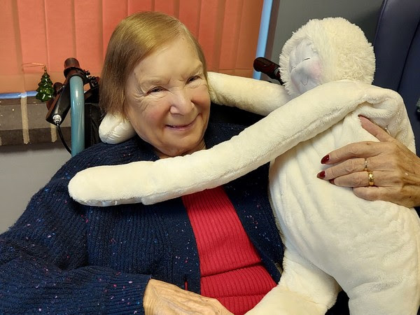 a woman cuddles a sensory dummy