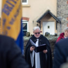 a reverend gives a reading outside at a memorial service