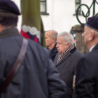 a man stood among veterans at memorial service