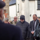 people bow their heads at a memorial service