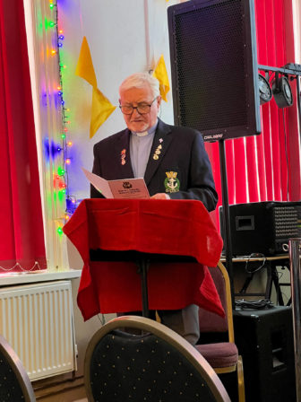 A reverend stands to say prayers