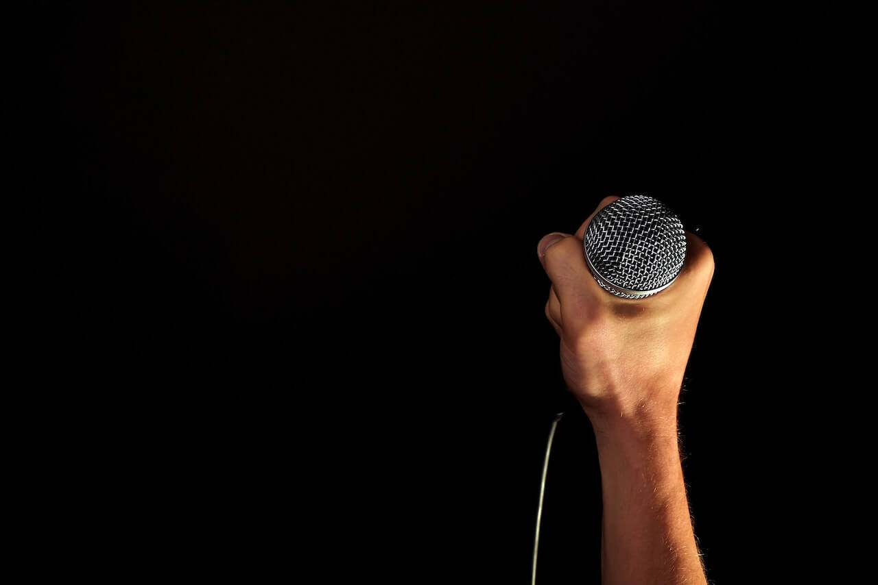 a hand holding a microphone