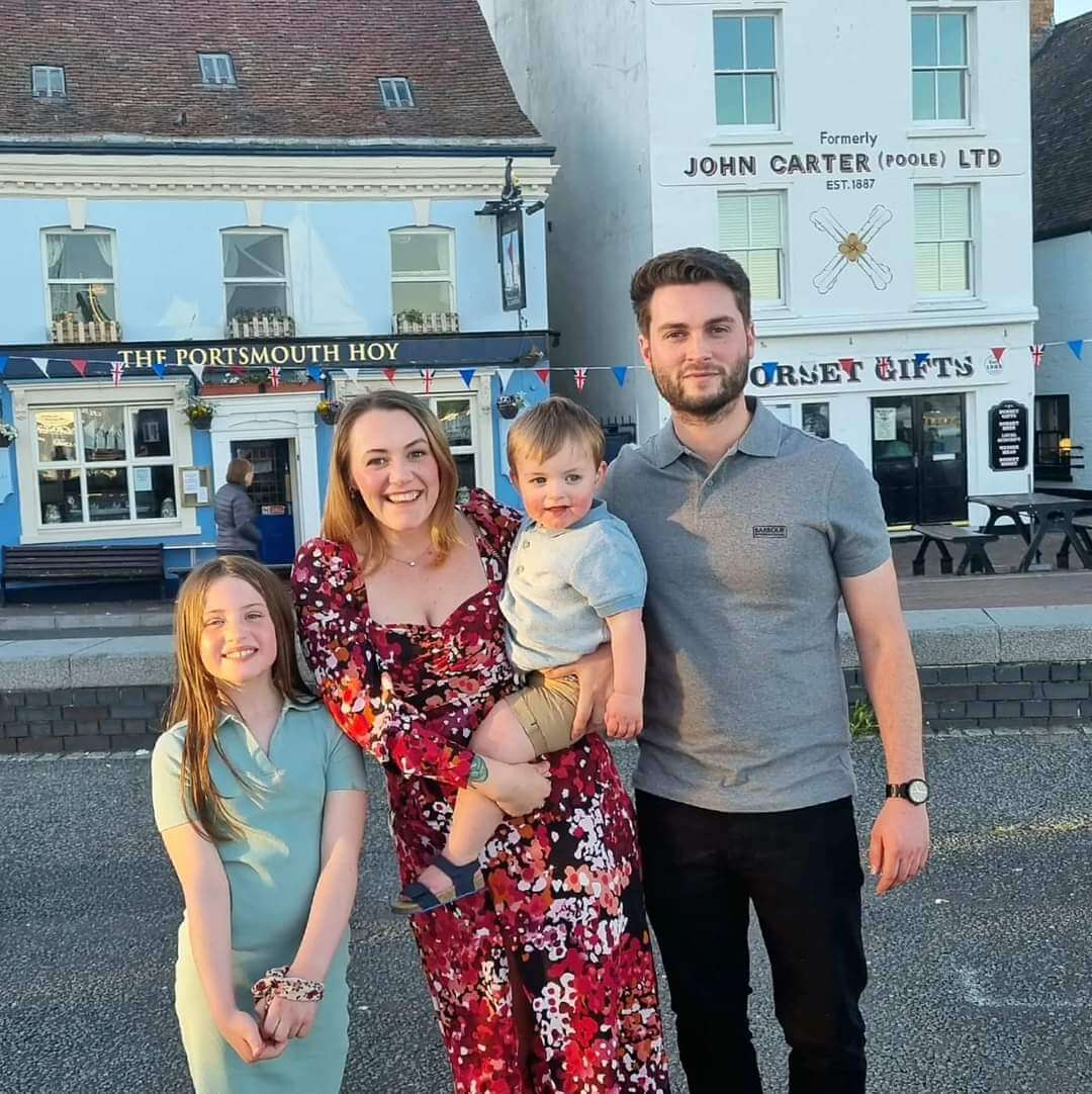 a family of four stood outside a pub
