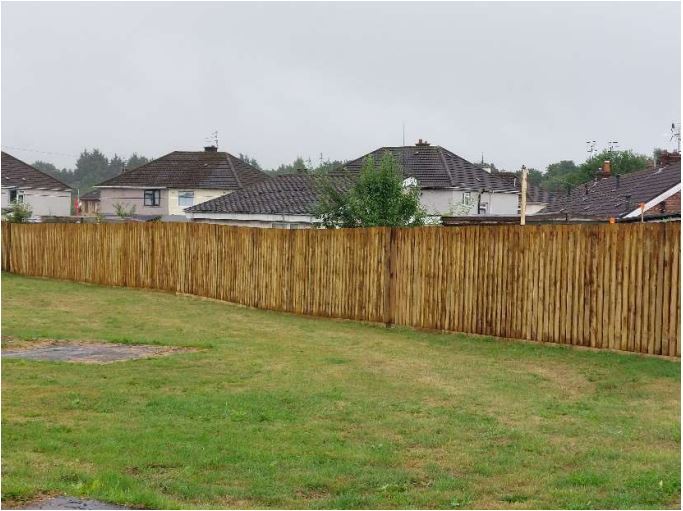 a field with a fence on the edge of it
