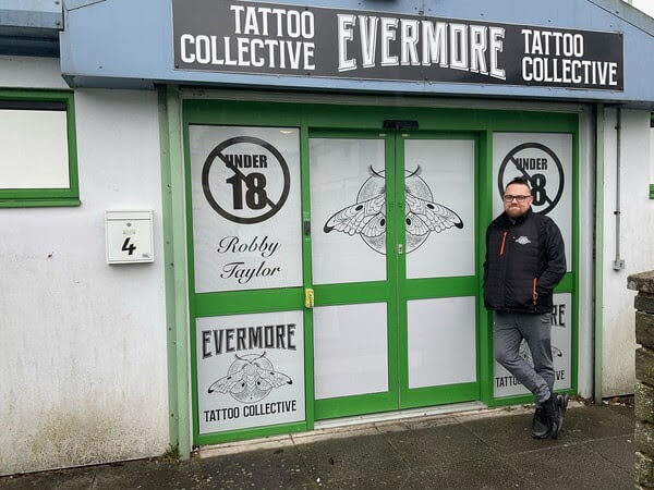 man outside tattoo shop