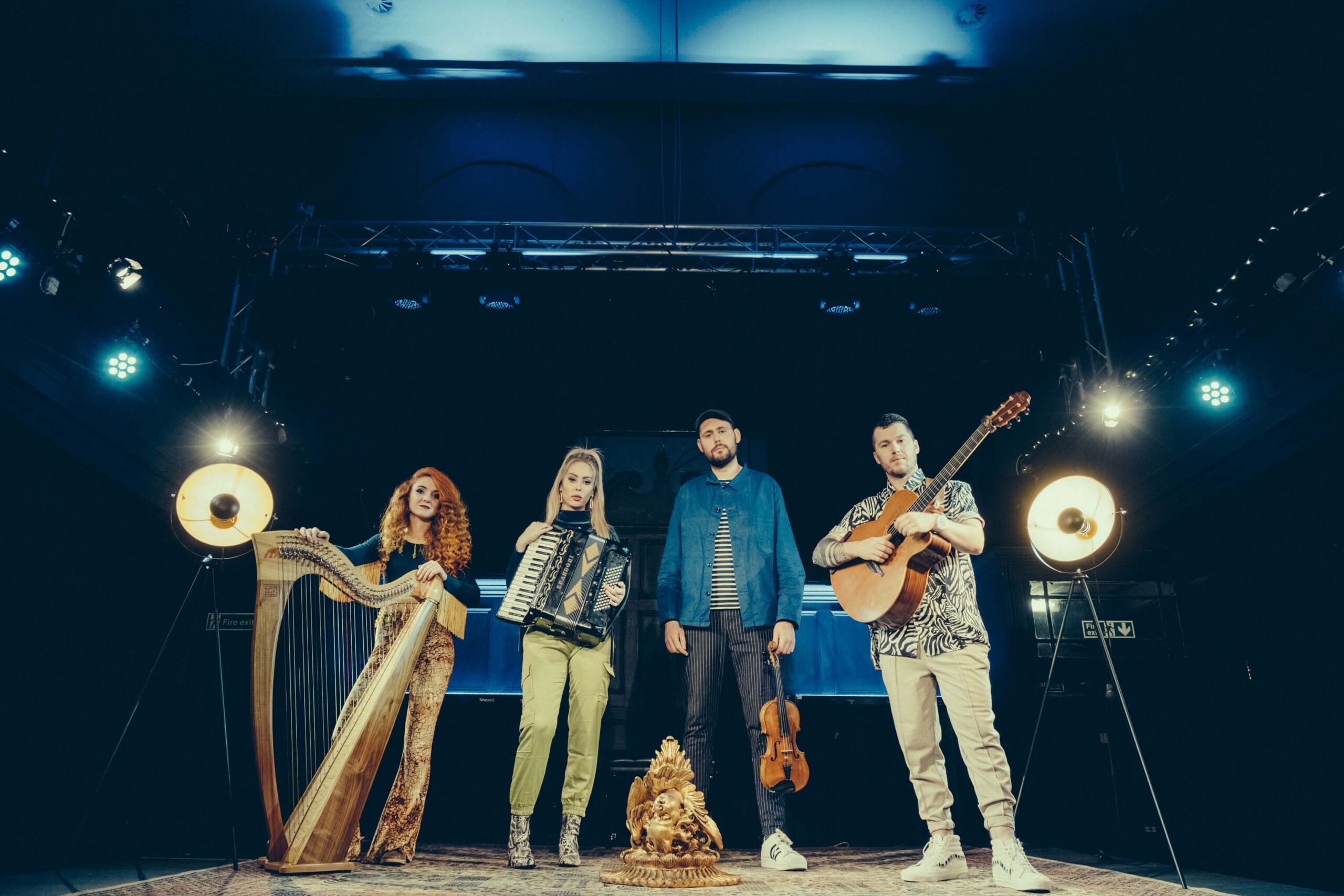 four band members on stage with their instruments