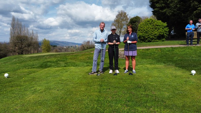 three golfers on tee smile for a photo