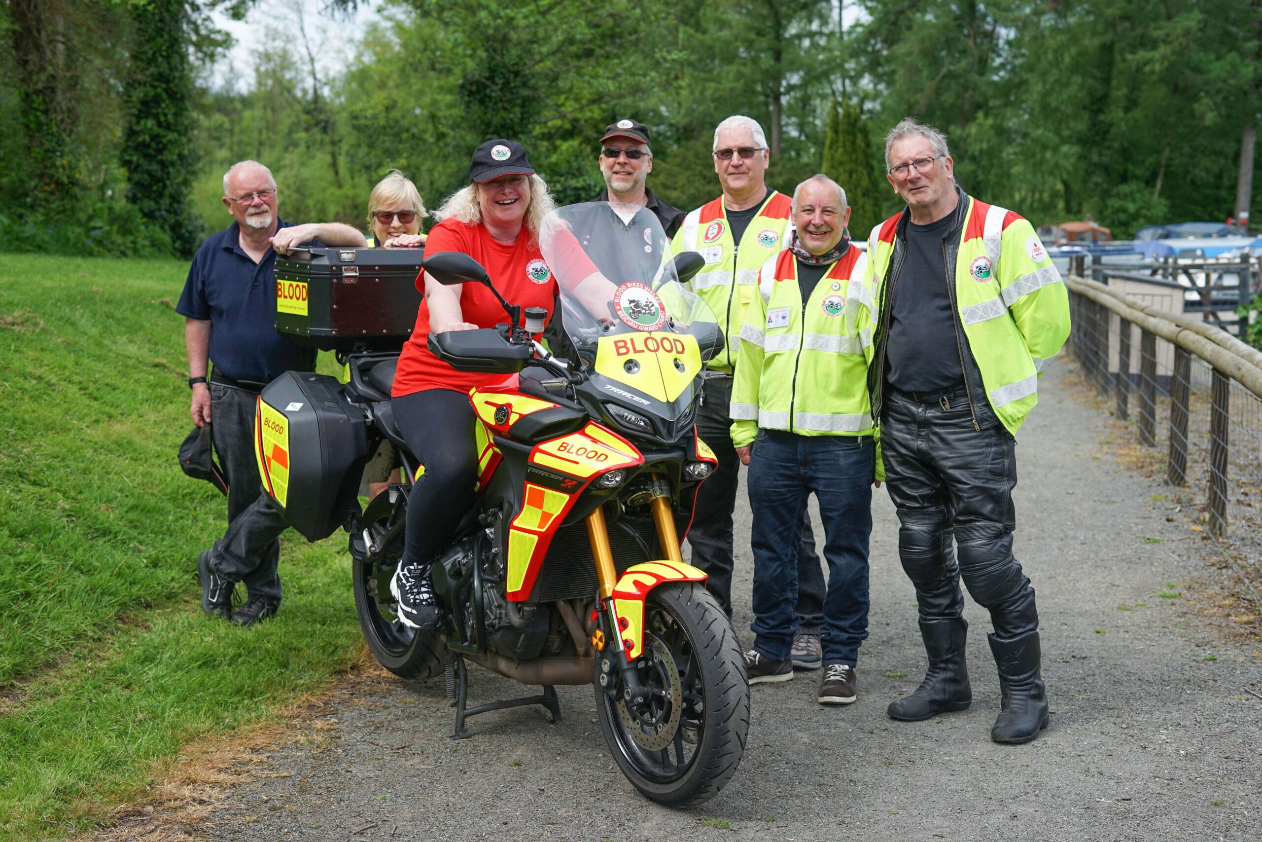 a group of people in high viz stood around a bike