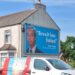 large poster of nigel farage on side of house