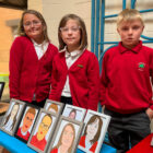 three pupils stood by a stall