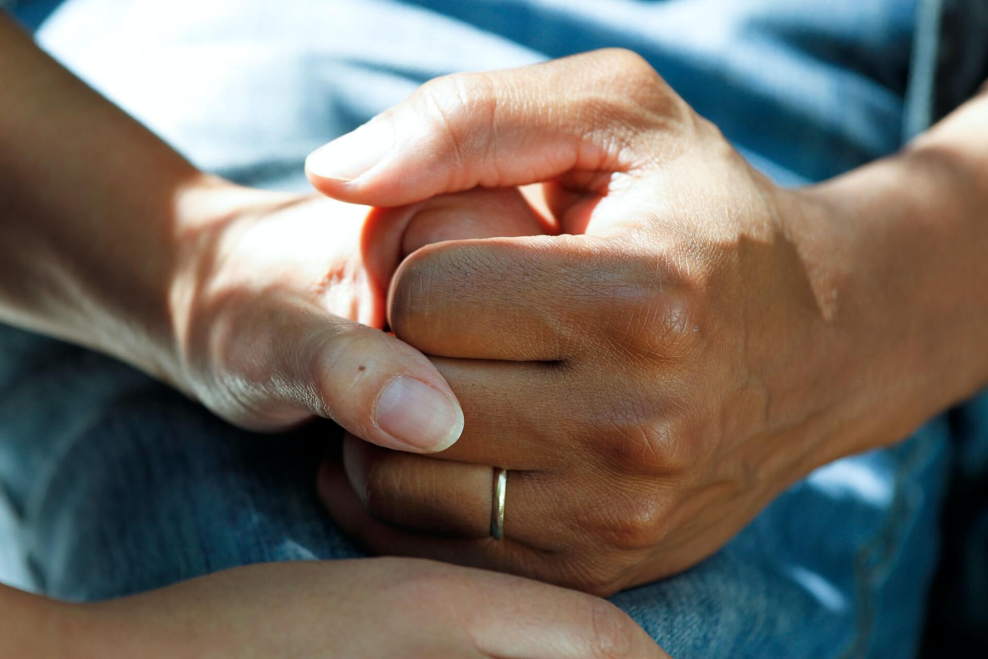 two hands grip each other