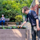 a boy waters plants