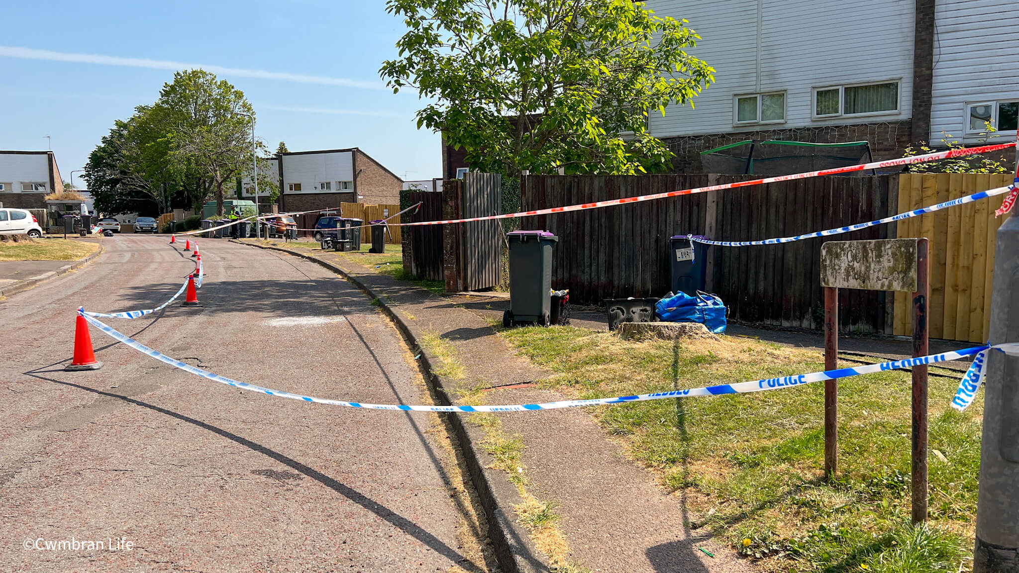 a police cordon- they have taped off an area of grass and road