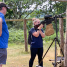 a woman tries out a machine gun at an military re-enactment event