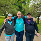 three men walking with arms around each other