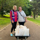 two women stood by a wheelbarrow