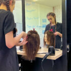 a hairdressing student cut hair on a plastic model