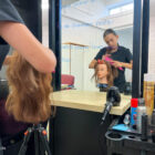 a hairdressing student brushes hair on a plastic model