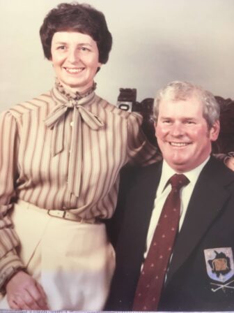 a couple sat arm in arm smiling