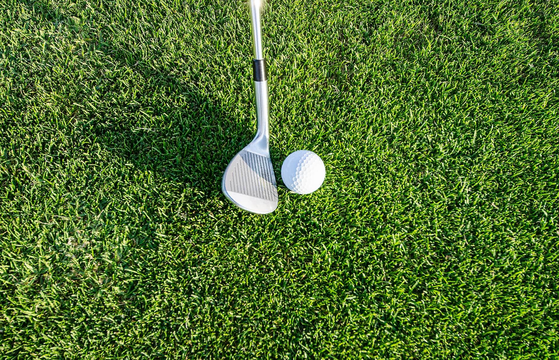 a putter about to hit a golf ball