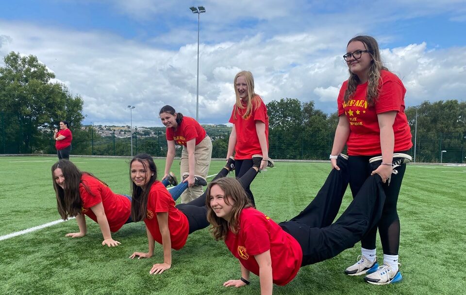 six young people playing wheelbarros